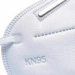 Mascarilla KN95 blanca con banda nasal metálica y costuras visibles, vista frontal en primer plano.