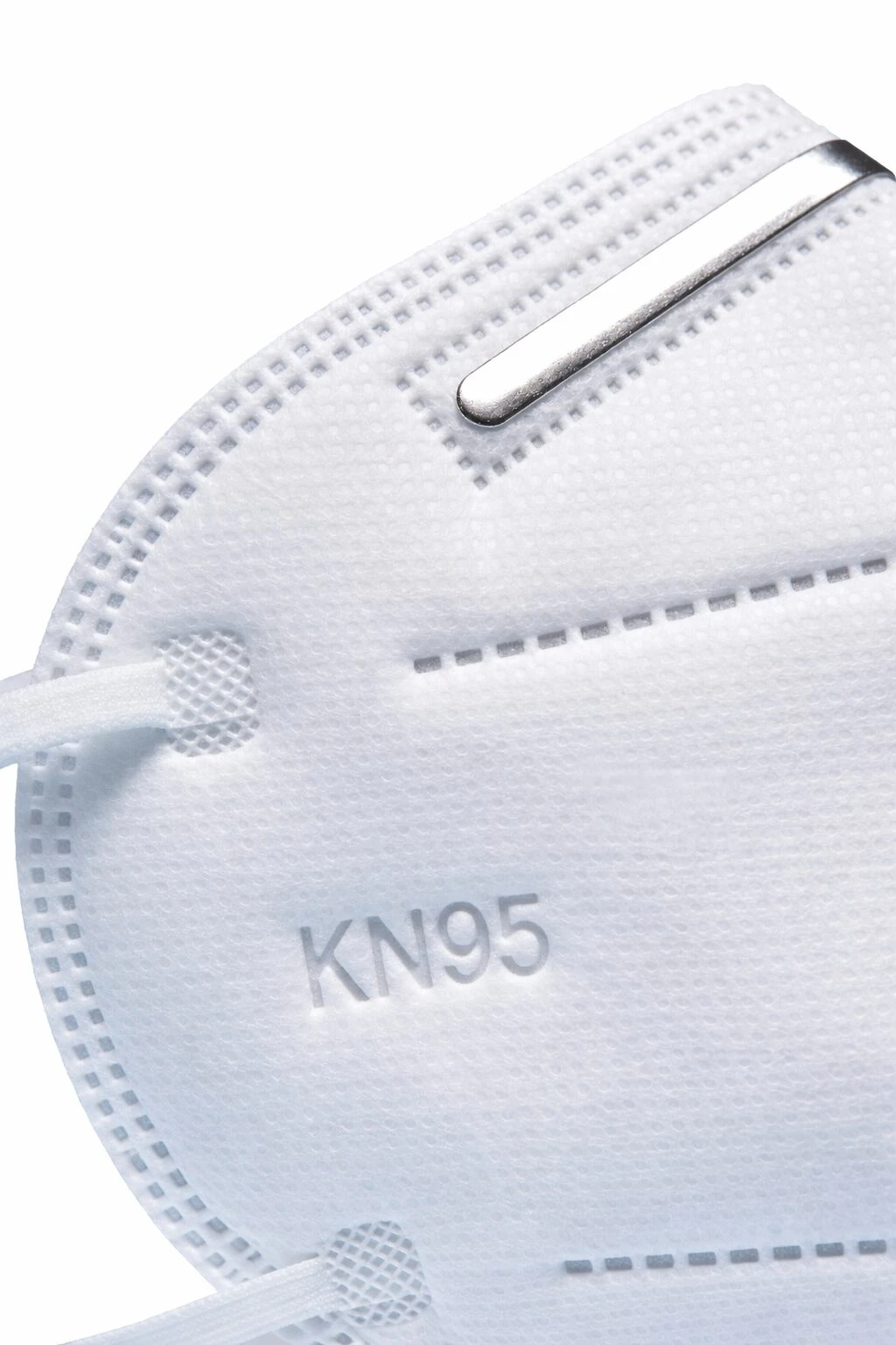 Mascarilla KN95 blanca con banda nasal metálica y costuras visibles, vista frontal en primer plano.