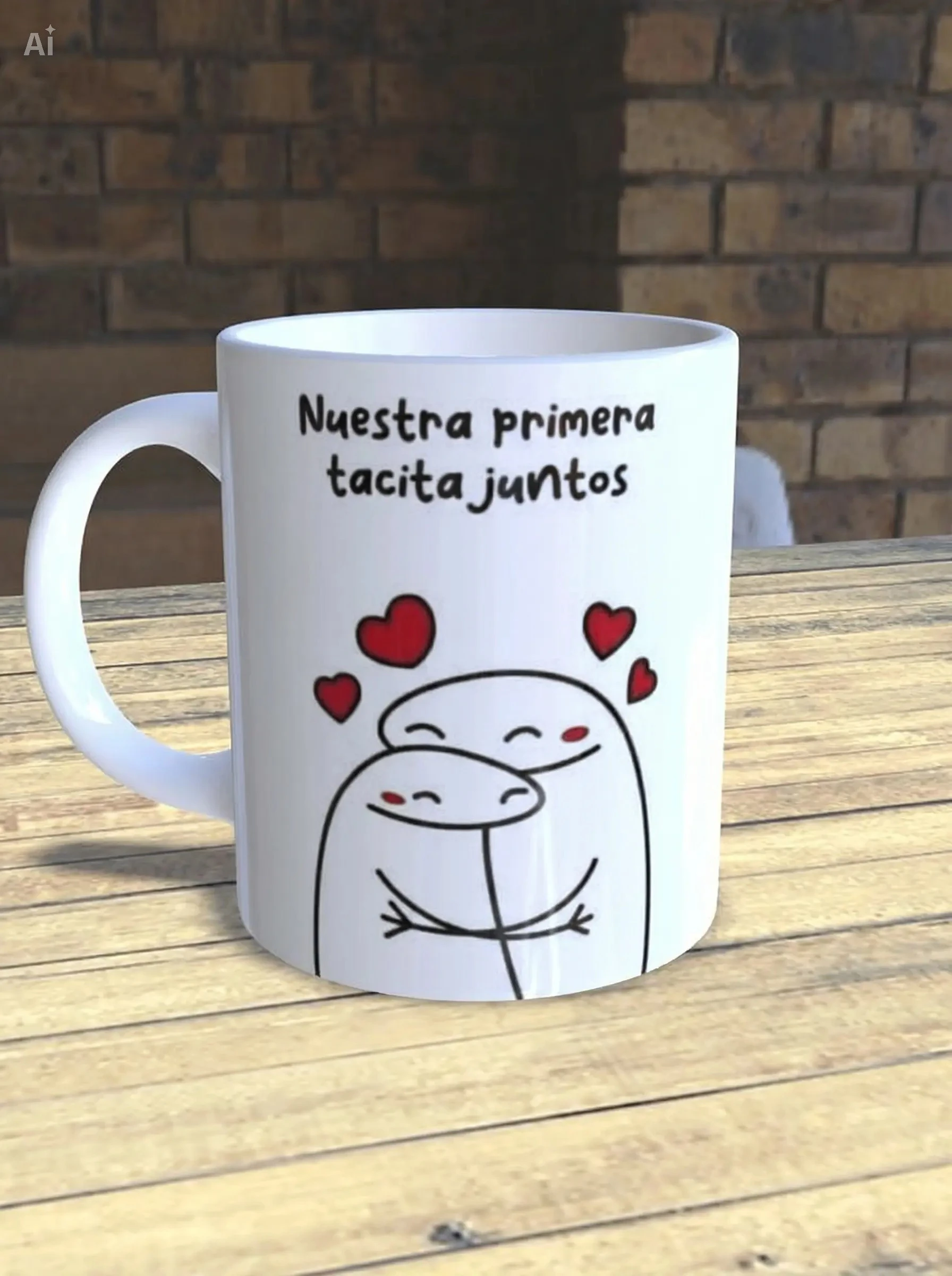 Taza de cerámica blanca con diseño de dos figuras abrazadas y corazones rojos, texto que dice "Nuestra primera tacita juntos", sobre mesa de madera.