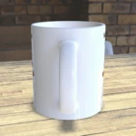 Taza de cerámica blanca con asa, vista lateral sobre mesa de madera. Parte de un set para pareja.