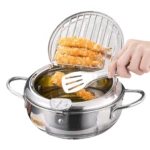 Olla freidora japonesa de acero inoxidable con tapa drenadora; mano colocando pollo empanizado en rejilla sobre aceite caliente.