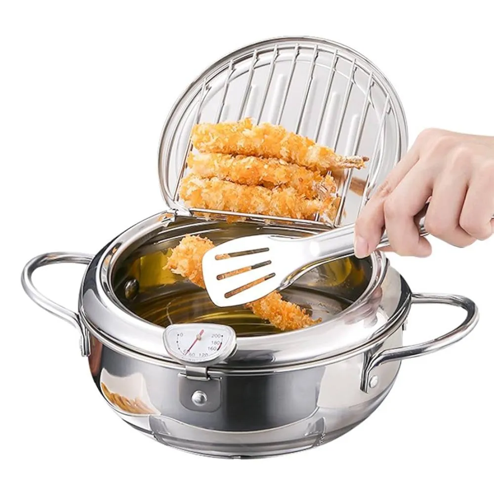 Olla freidora japonesa de acero inoxidable con tapa drenadora; mano colocando pollo empanizado en rejilla sobre aceite caliente.