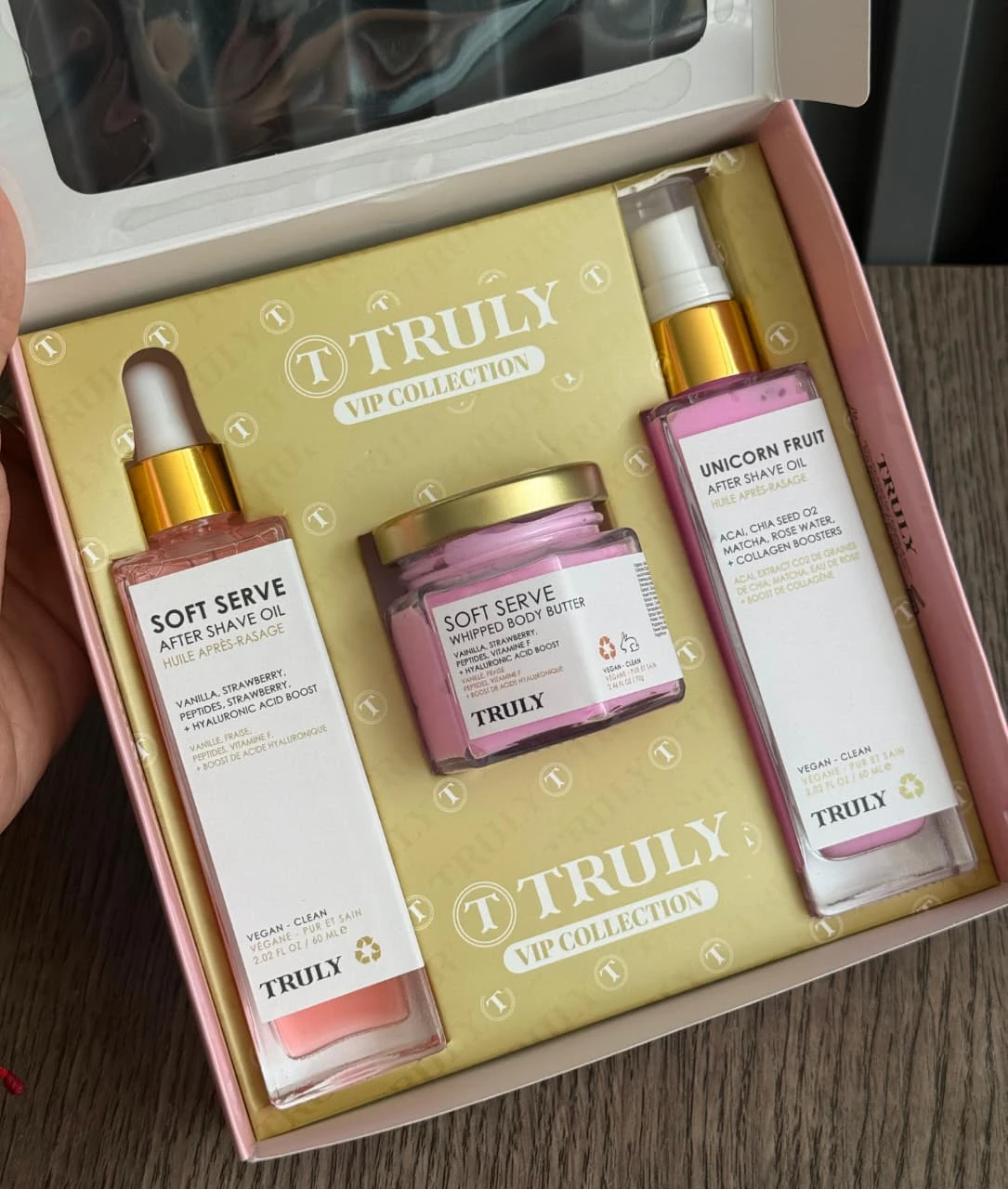 Kit de cuidado corporal Truly con aceite después de afeitado, crema corporal y aceite corporal en caja rosa.