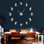 Reloj de pared con figuras de Mickey Mouse en acrílico reflectante, sobre fondo azul oscuro, en sala de comedor con mesa y sillas.