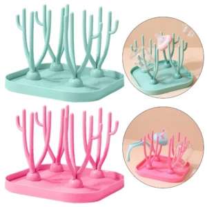 Escurridor de teteros en colores menta y rosa, con estructura de ramas para secar biberones y accesorios de bebé. Incluye detalles de uso con botellas y chupetes.