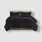 Edredón térmico peludo negro para cama doble, con dos almohadas y cabecero de madera clara.