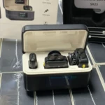 Micrófono inalámbrico profesional SX23 en estuche abierto, mostrando receptor y micrófono de solapa sobre superficie oscura.
