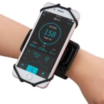 Holder deportivo negro con correa elástica, sujetando un iPhone rosa en brazo. Pantalla encendida mostrando datos de actividad física: calorías, pasos y tiempo. Diseño ergonómico para uso durante ejercicio.