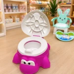 Orinal tortuga fucsia con tapa blanca y asiento blanco, diseñado para facilitar el control de esfínteres en bebés.