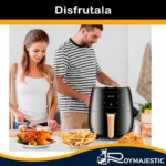 Freidora de aire digital negra con panel táctil y mango dorado, sobre mesa de cocina con personas preparando comida crujiente sin aceite.
