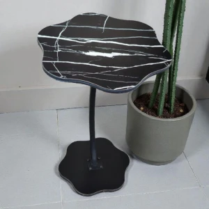 Mesa auxiliar Flower Vintage con superficie de mármol negro y vetas blancas, base metálica negra y diseño orgánico en forma de flor.
