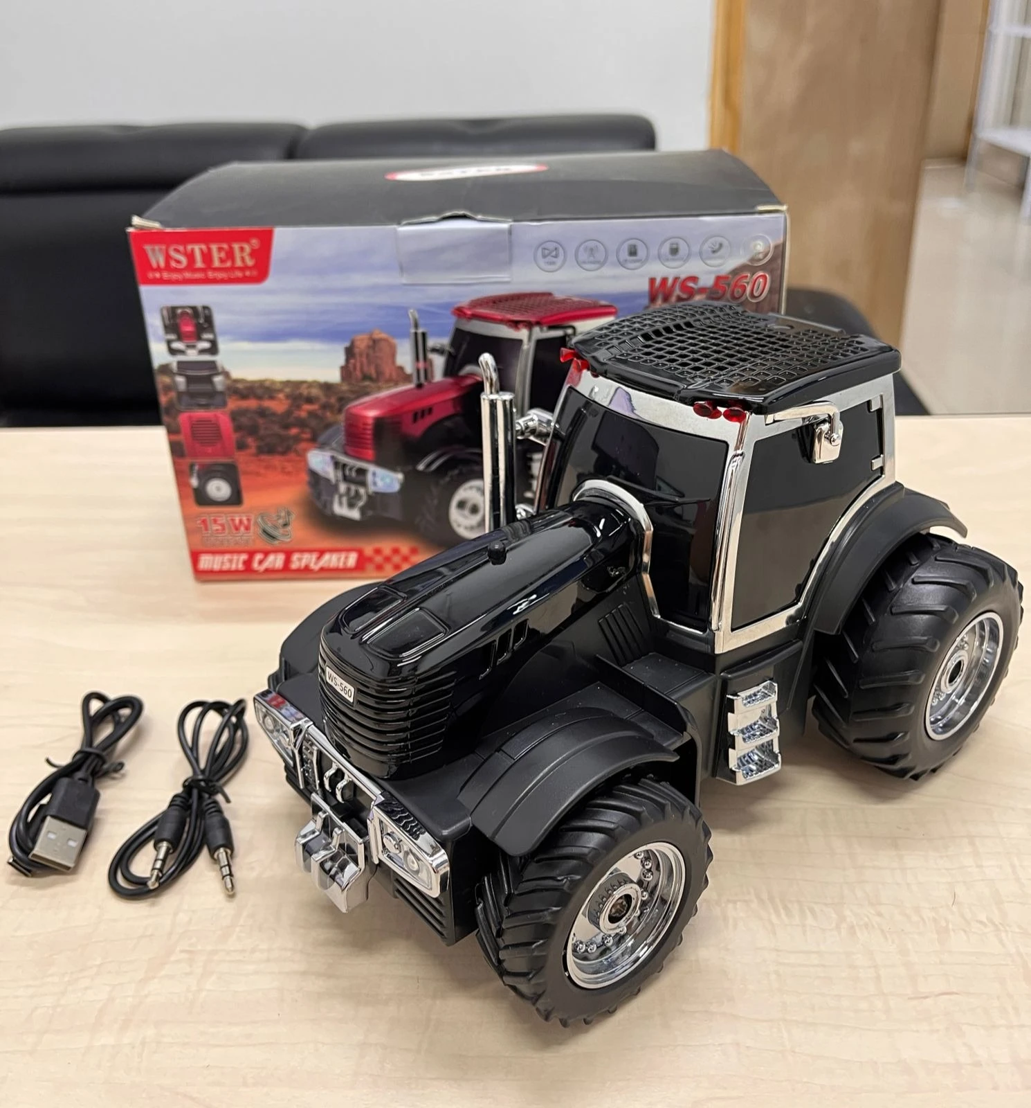 Tractor negro con detalles cromados y neumáticos grandes, modelo WS-560 de la marca WSTER. Incluye caja original, cargador USB y cable de audio.