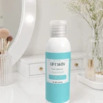 Botella de crema reafirmante Lift Skin en tono azul claro, sobre mesa de tocador con espejo y accesorios de belleza al fondo.