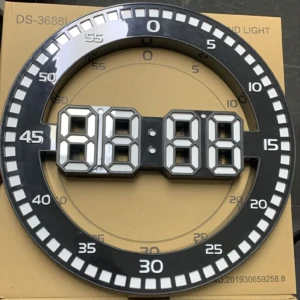 Reloj digital de pared grande con números LED blancos y marco negro, sobre caja de cartón marrón. Muestra hora 8:88 y escala circular de minutos.