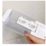 Dispensador de jabón líquido transparente de 500 ml en ABS, con tapa blanca y dos dispensadores internos visibles, sostenido por mano.