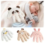Almohada inteligente Mano Arrulla para bebé en color blanco con diseño de panda, mostrando textura de puntos y forma de mano. Incluye variante en tonos beige y rosa con diseños de oso y conejo.