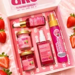 Kit de viaje URO con cinco productos: jabón íntimo, loción corporal, serum facial, crema hidratante y jabón corporal. Presentado en caja rosa con detalles de fresas.