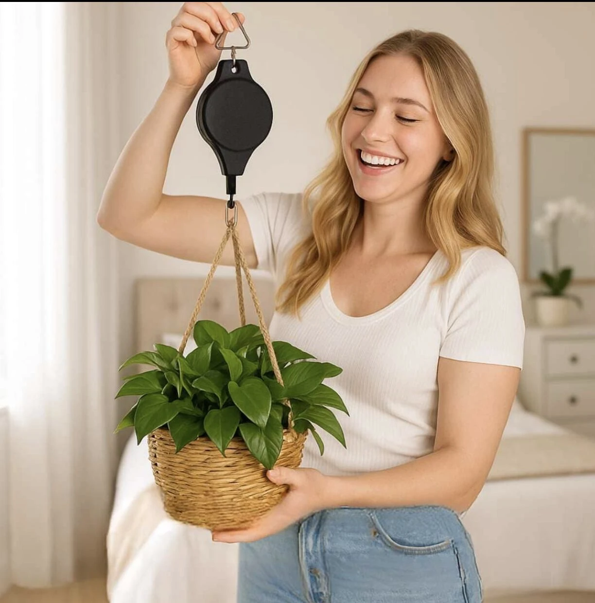 Mujer sonriente sosteniendo maceta colgante con soporte de polea negro, en habitación luminosa.