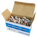 Caja abierta con clavos integrados de acero aleación, cabezas blancas y puntas rojas, dispuestos en interior del empaque. Ideal para fijación de vigas y techos.