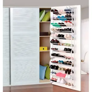Zapatero colgante vertical blanco con 24 niveles, instalado en puerta de armario abierto, mostrando variedad de calzado organizado por niveles.