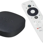 Dispositivo negro de streaming Onn Google TV 4K con control remoto blanco, ambos sobre fondo blanco.