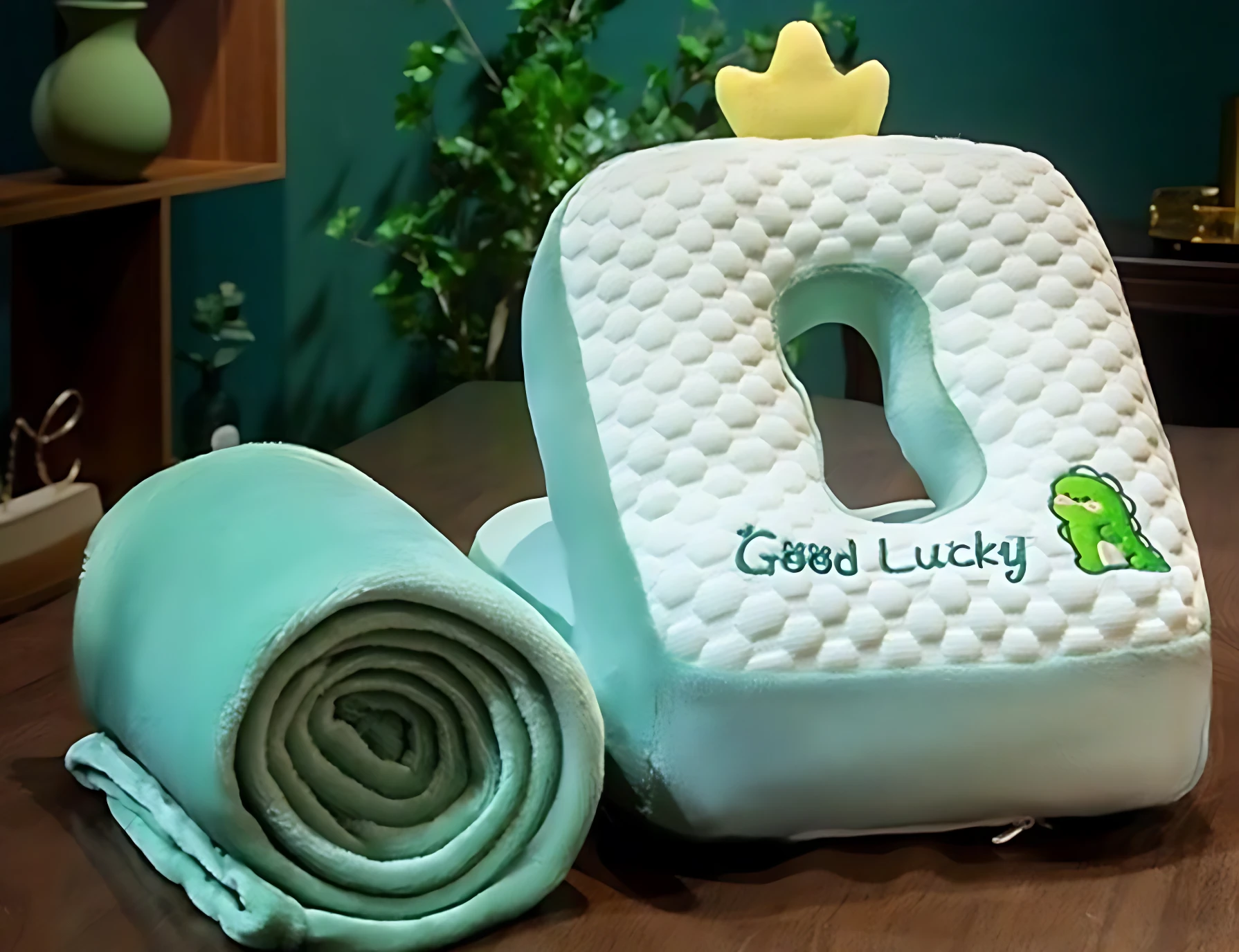 Almohada ergonómica de seda con forma de corona, color turquesa y blanco, con funda extraíble y diseño de textura de burbujas. Incluye funda enrollada al lado.