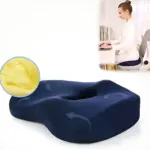 Cojín ergonómico azul con diseño abultado para aliviar presión en coxis, mostrando textura interior amarilla y uso en silla de oficina.