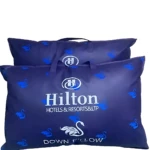Almohada Hilton Down con relleno de plumas sintéticas, color azul oscuro, con logotipo y patrones de cisnes.