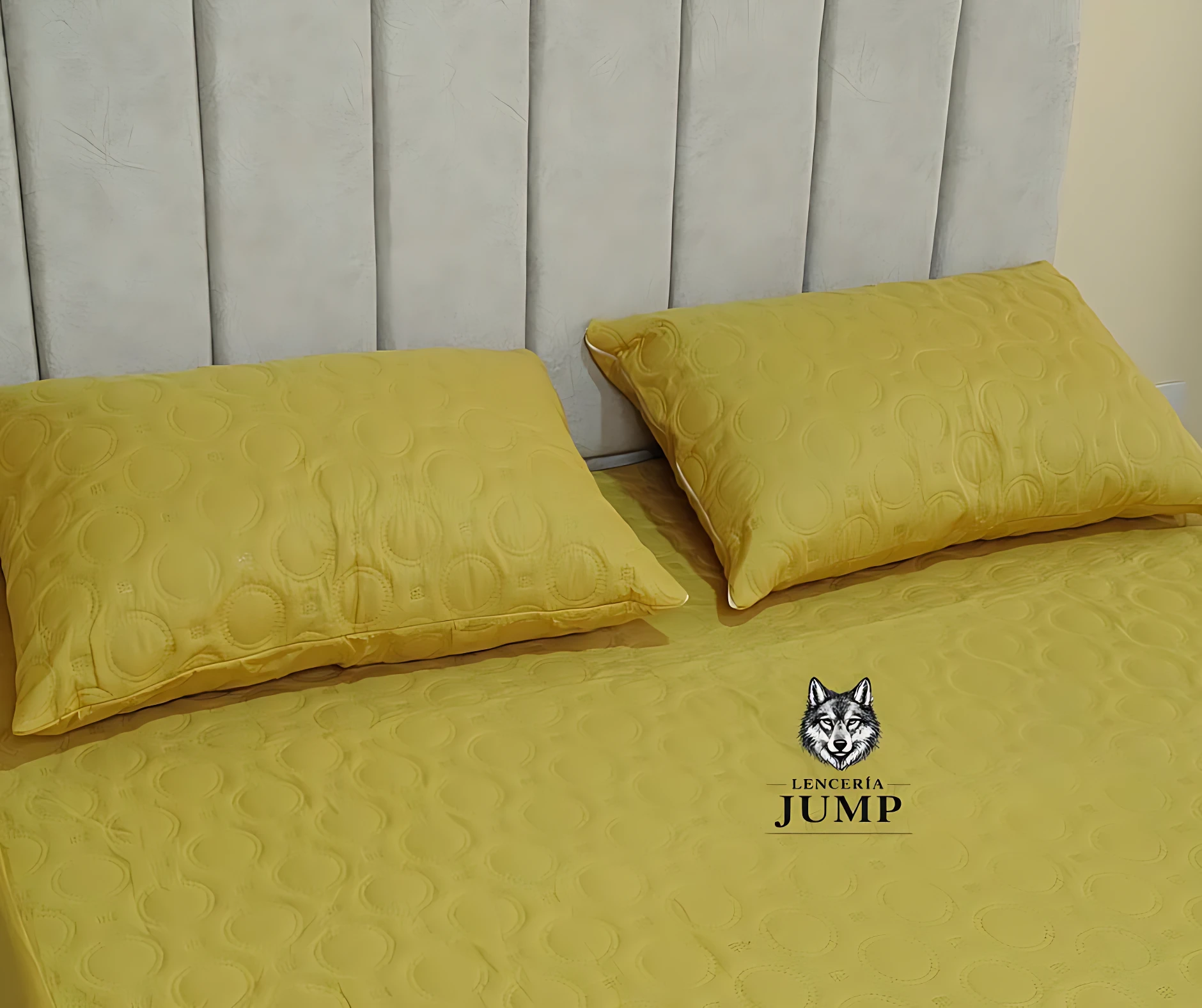 Set de dos almohadas amarillas con textura acolchada, sobre cama con cabecero blanco.