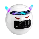 Altavoz Bluetooth blanco con forma de cabeza de demonio, cuernos multicolores, pantalla LED mostrando hora 02:13 PM y detalles rojos en forma de ojos.