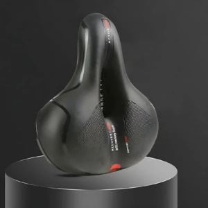 Asiento ergonómico negro con relieve central y textura perforada, diseñado para bicicletas de ruta; reduce presión en nalgas y mejora circulación.