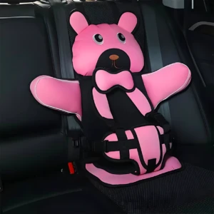 Asiento seguridad portátil para niños en color rosa con diseño de oso, instalado en asiento trasero de vehículo. Incluye arnés de tres puntos y almohadillas acolchadas.