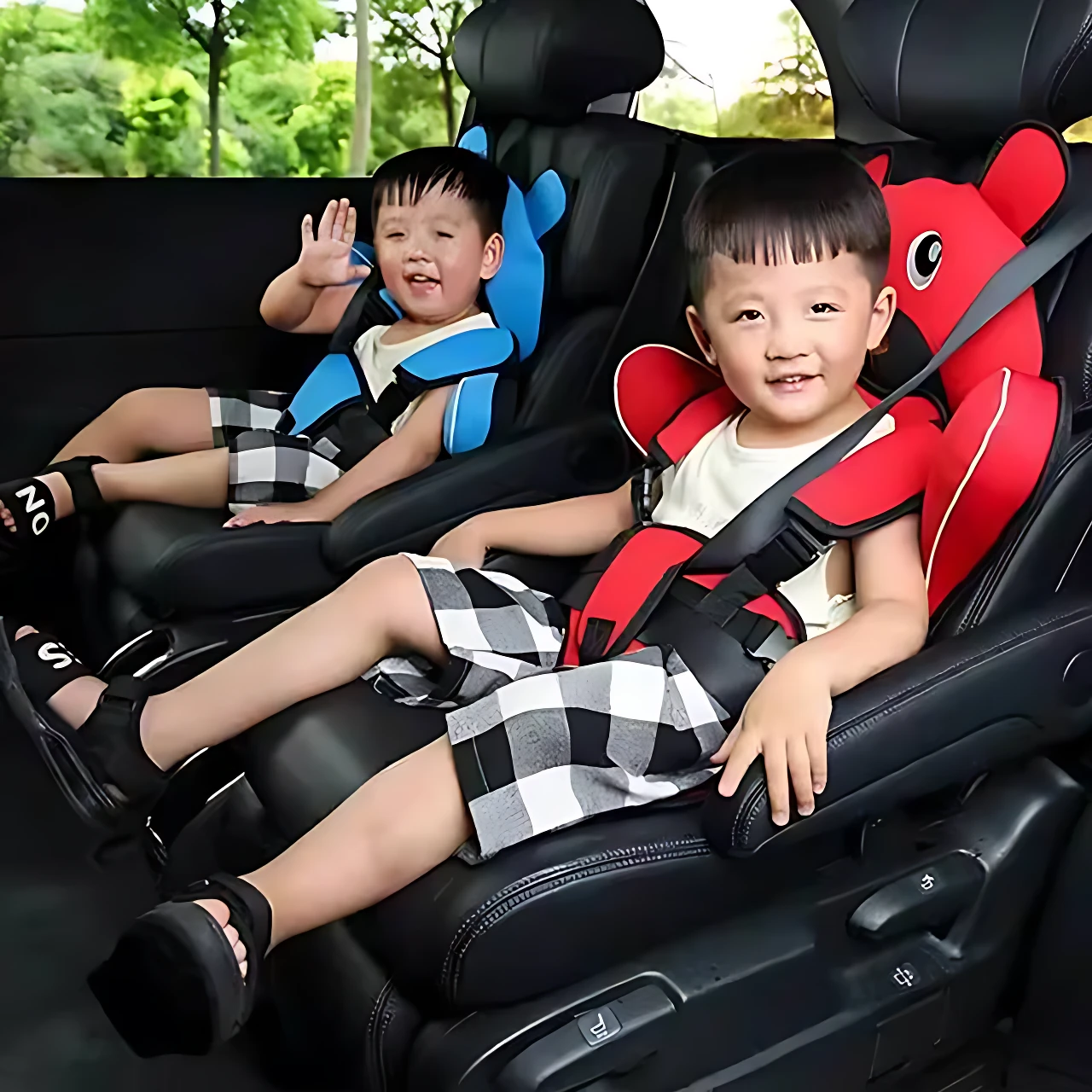Dos niños en asientos de seguridad portátiles para autos, uno rojo y otro azul, instalados en el interior de un vehículo.