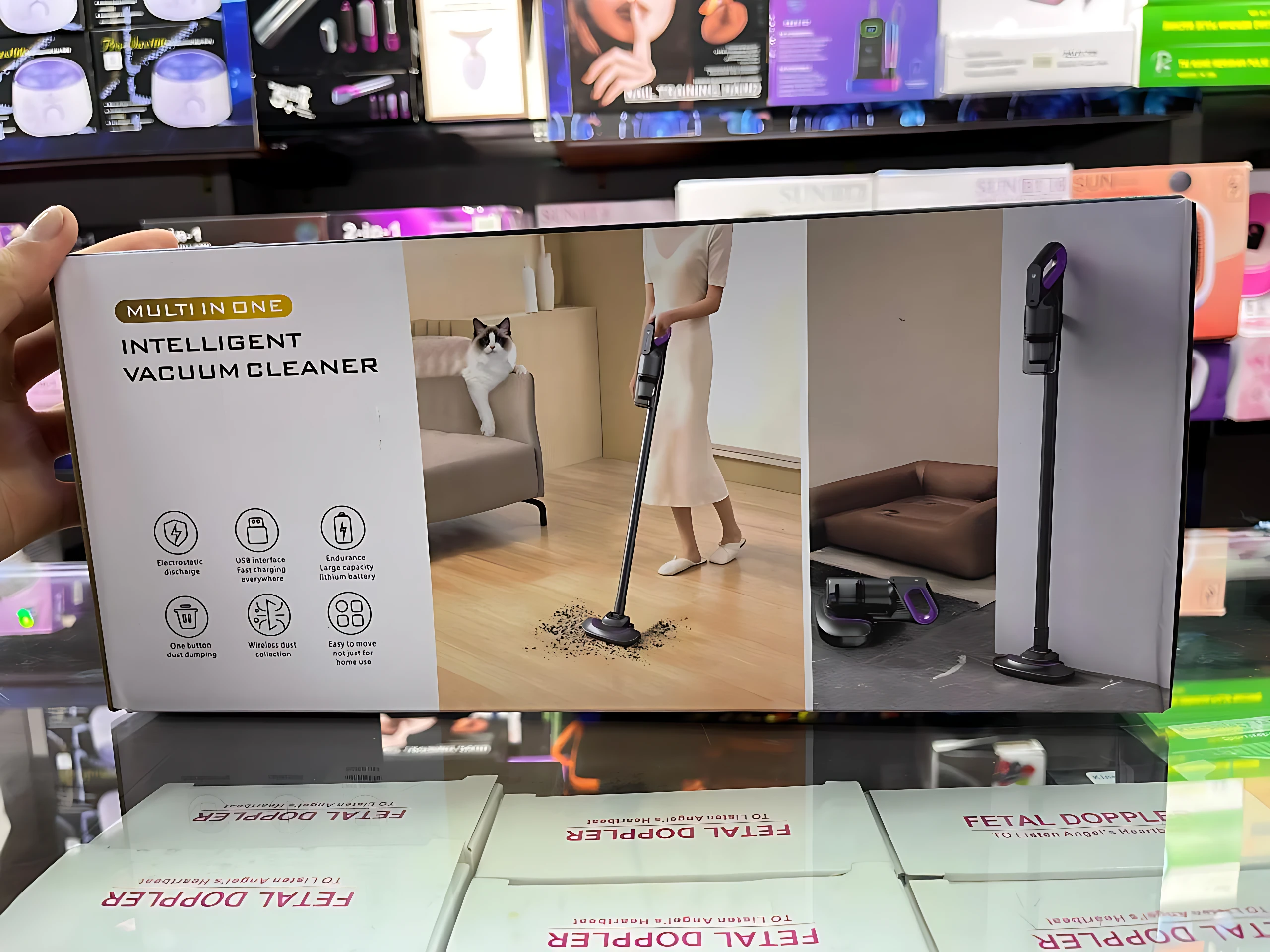 Aspiradora inteligente 2 en 1, caja blanca con de mujer usándola en sala y gato observando, detalles de accesorios y diseño compacto.