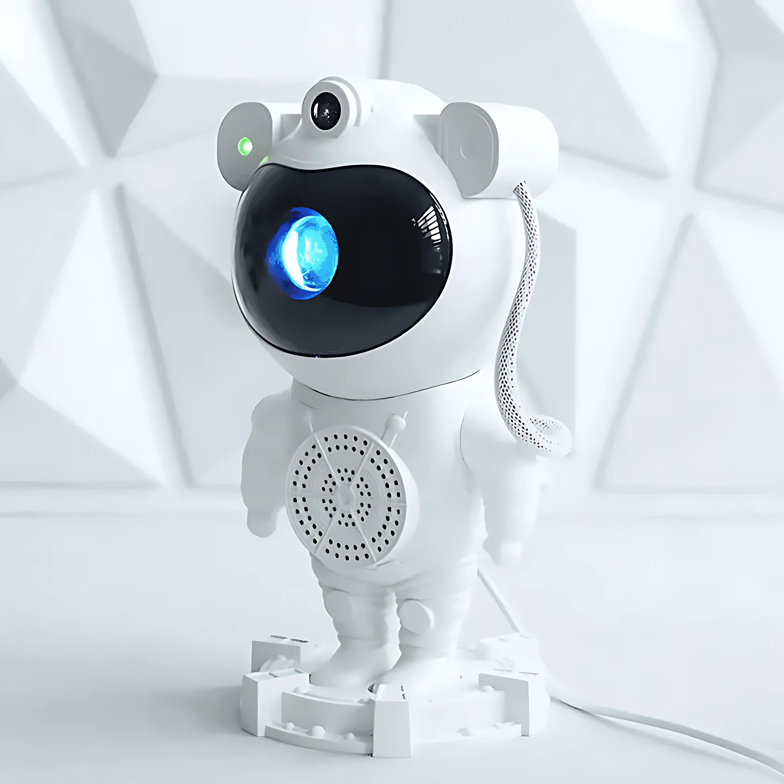 Proyector astronauta blanco con ojo azul brillante, antenas redondas y base de soporte. Diseño futurista para ambientación nocturna.