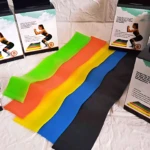 Set de cinco bandas de resistencia en colores verde, naranja, amarillo, azul y negro, dispuestas sobre superficie blanca con cajas de presentación visibles.