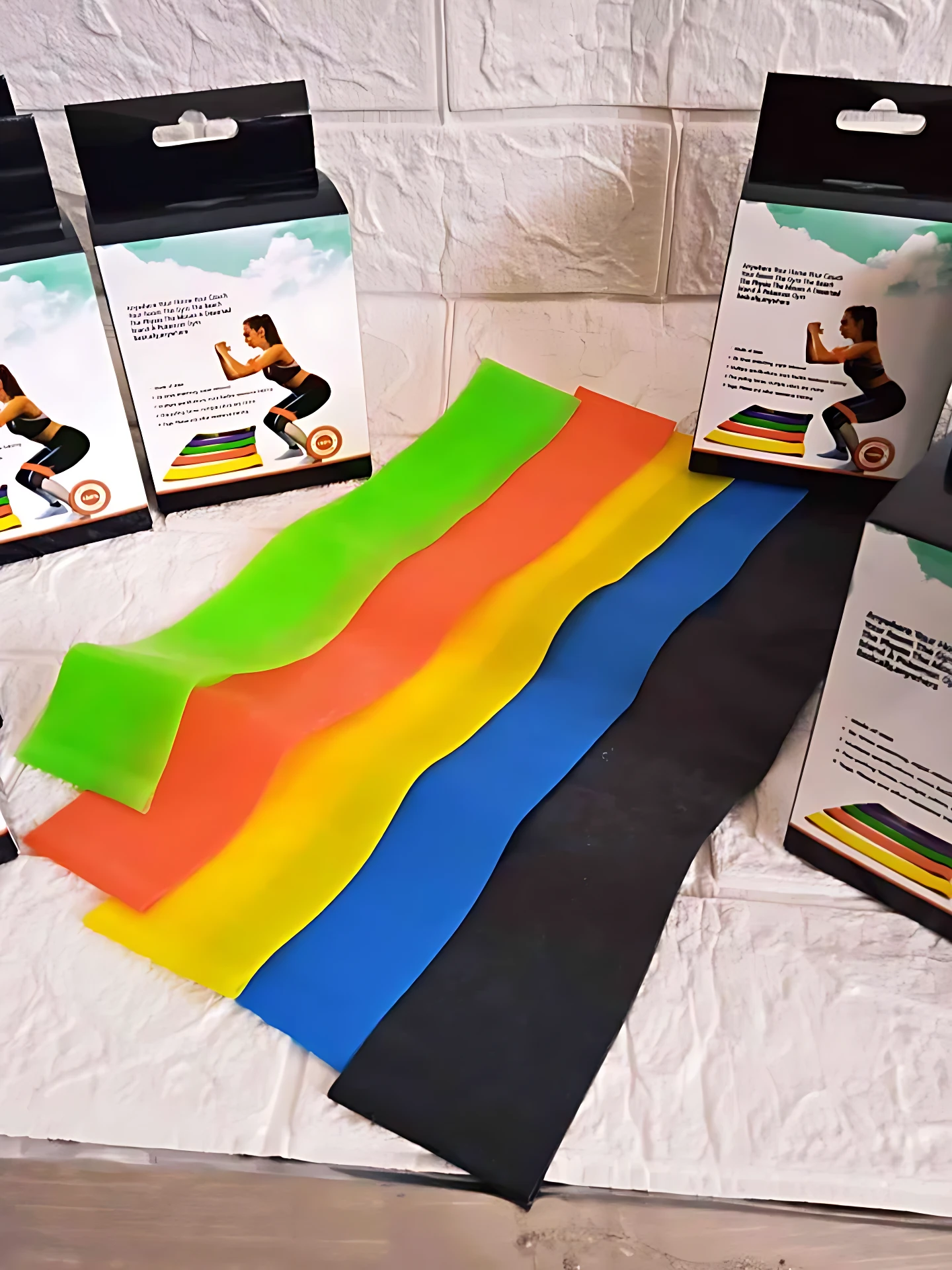Set de cinco bandas de resistencia en colores verde, naranja, amarillo, azul y negro, dispuestas sobre superficie blanca con cajas de presentación visibles.