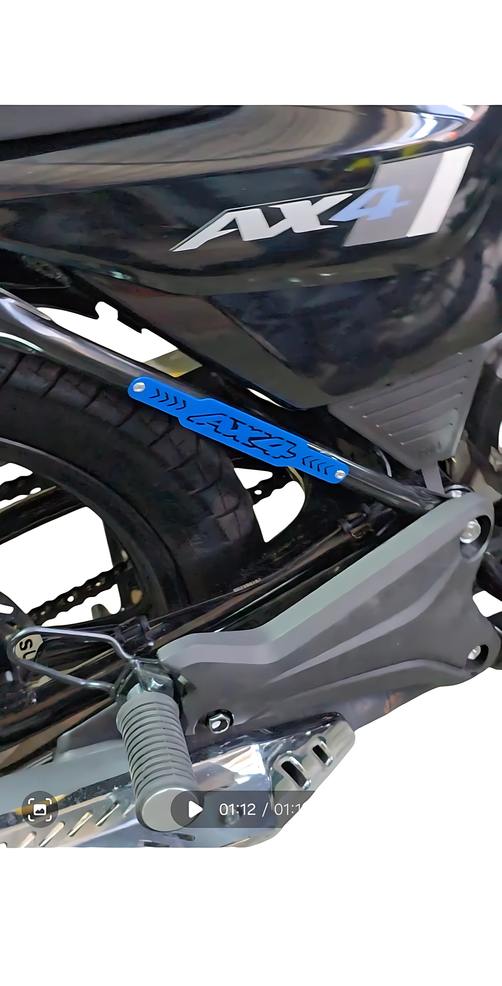 Barra estabilizadora trasera tubular Ax4 en acero inoxidable, instalada en motocicleta negra, protegiendo chasis lateral con acabado brillante y logotipo visible.