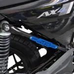 Barra estabilizadora trasera tubular Ax4 en acero inoxidable, instalada en motocicleta negra, con logotipo azul visible y protección contra impactos en chasis.