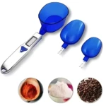 Báscula digital de cocina con tres recipientes azules y tres muestras de ingredientes: polvo rojo, harina blanca y granos marrones.