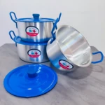 Batería de ollas de acero inoxidable con asas azules y tapas, mostrando tres recipientes apilados y uno inclinado sobre superficie gris.