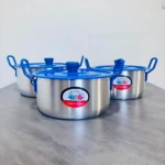 Set de tres ollas de acero inoxidable con tapas y asas azules, dispuestas en fila sobre superficie gris.