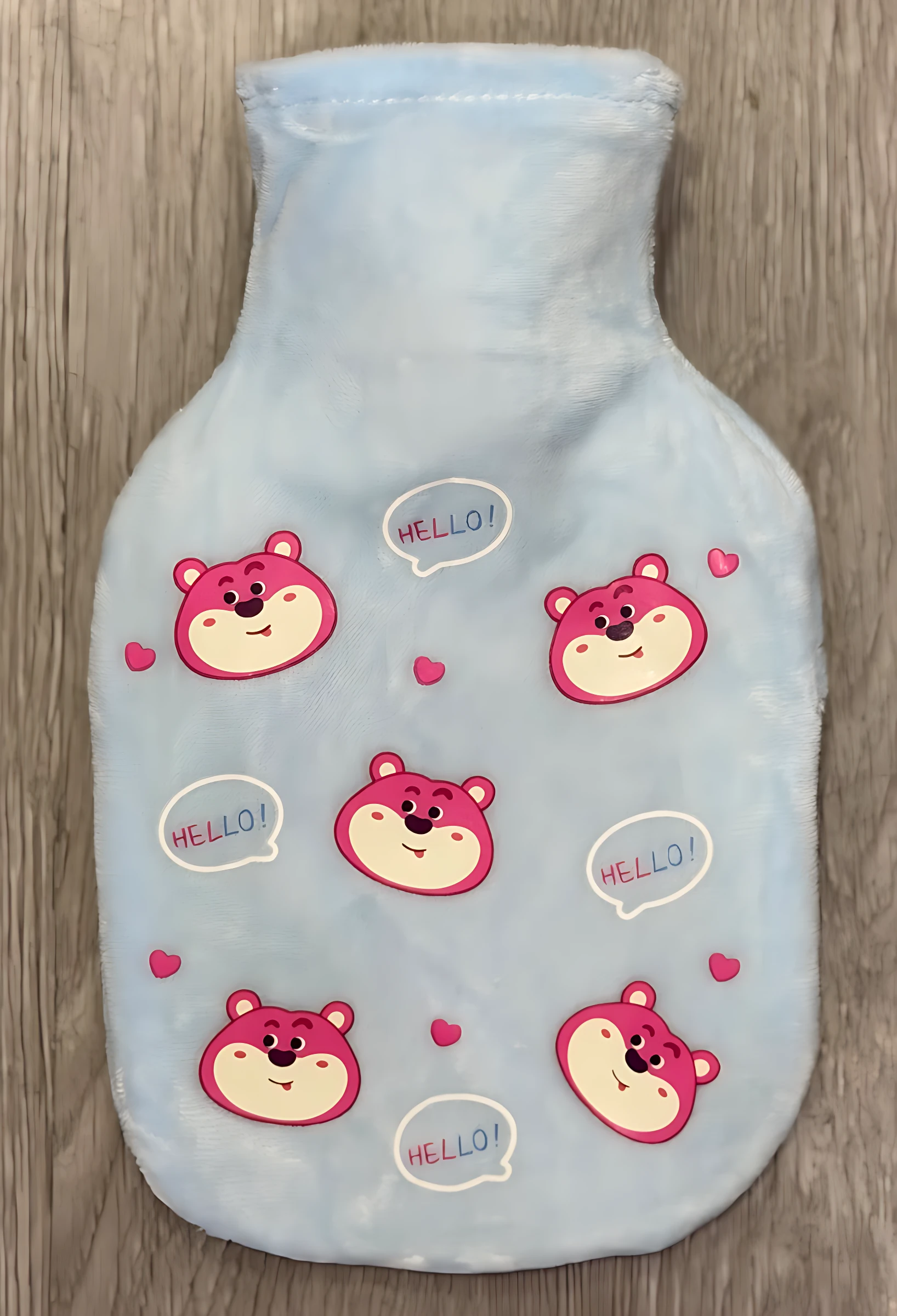 Bolsa térmica azul claro con estampado de ositos rosas y corazones, sobre fondo de madera.