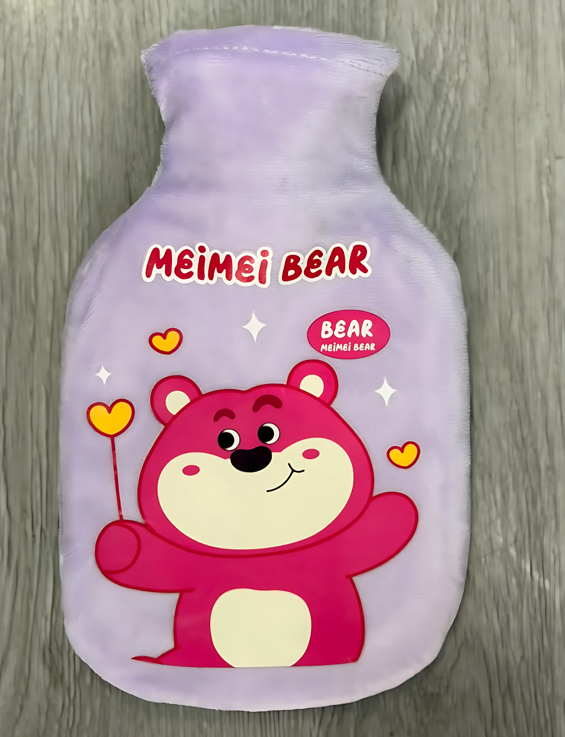 Bolsa térmica de 350 ml en color lila con estampado de oso rosa sonriente, ideal para aliviar cólicos menstruales y dolores musculares con calor húmedo.
