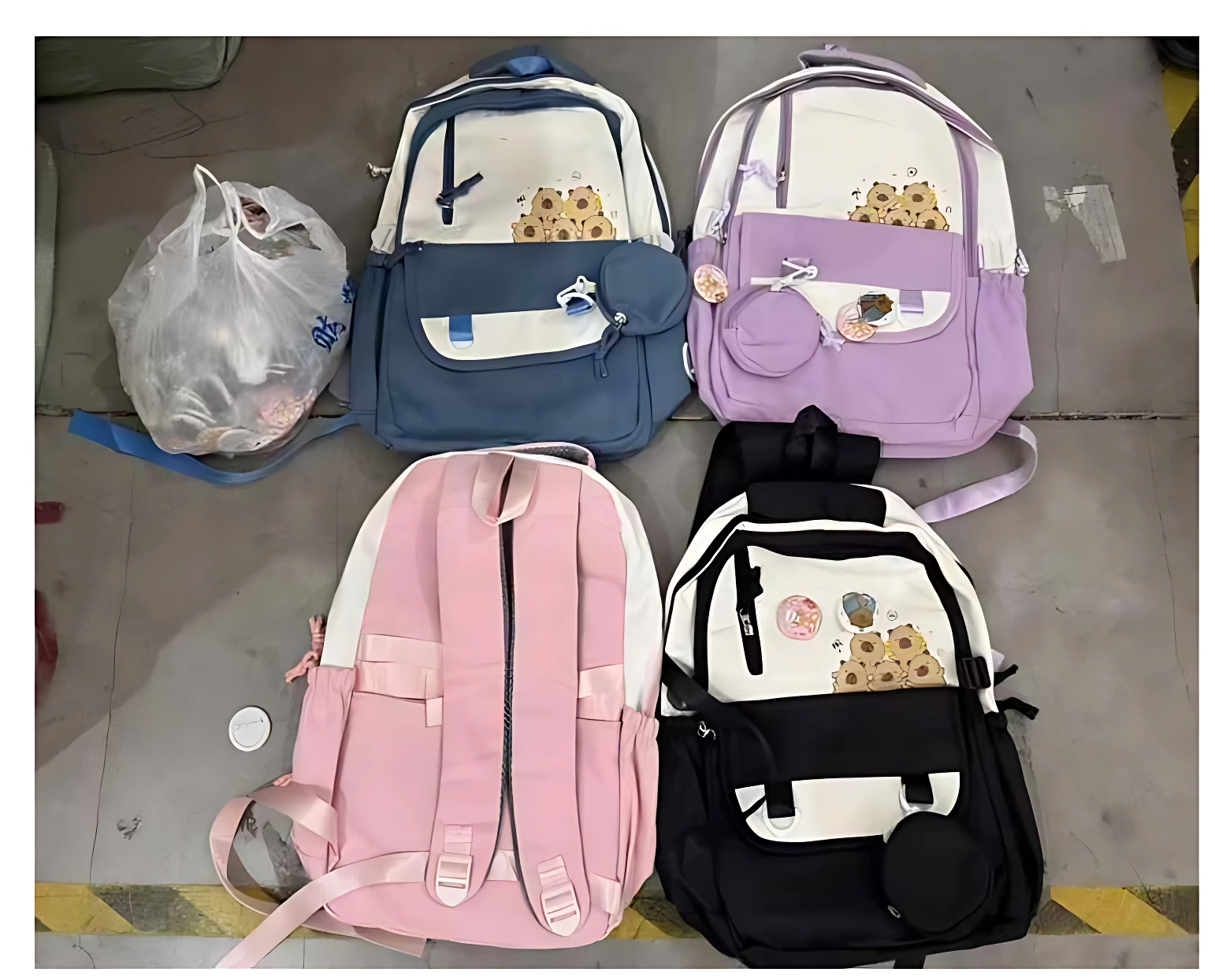 Cuatro mochilas juveniles con estampado de girasoles, en colores azul, lila, rosa y negro, dispuestas sobre suelo de baldosas.
