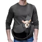 Bolso cargador canguro para mascotas pequeño en color gris oscuro, con perro chihuahua dentro, usado por hombre con camiseta negra y jeans.