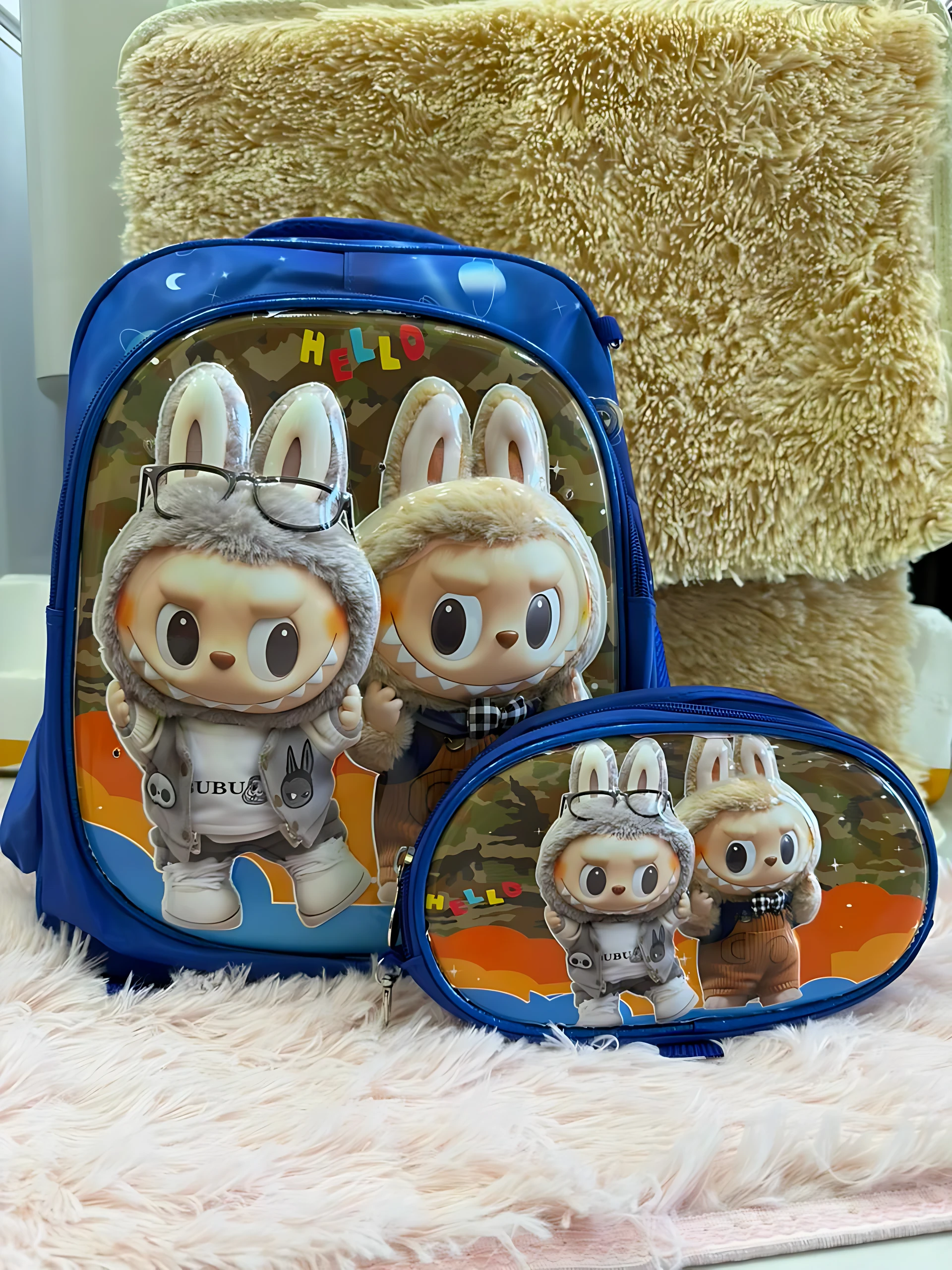 Mochila escolar azul con personajes de conejo, incluye lonchera y cartuchera con diseño coordinado.