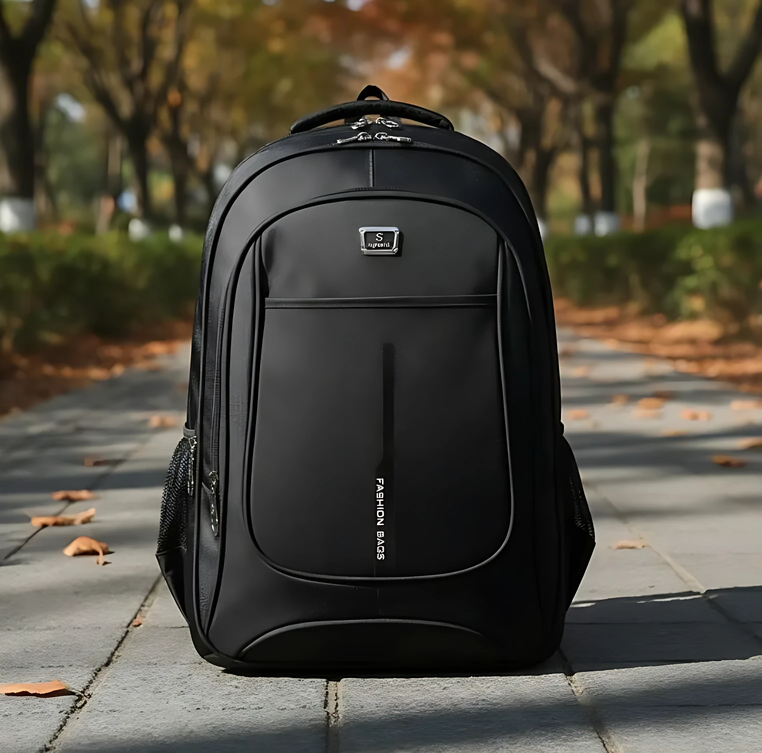 Mochila urbana Oxford negra de 45 litros, con compartimento para laptop de 17 pulgadas, visible en primer plano sobre camino adoquinado con hojas caídas.