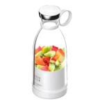 Licuadora portátil blanca con tapa metálica y mango, mostrando fruta cortada dentro de su recipiente transparente. Ideal para batidos saludables en movimiento.