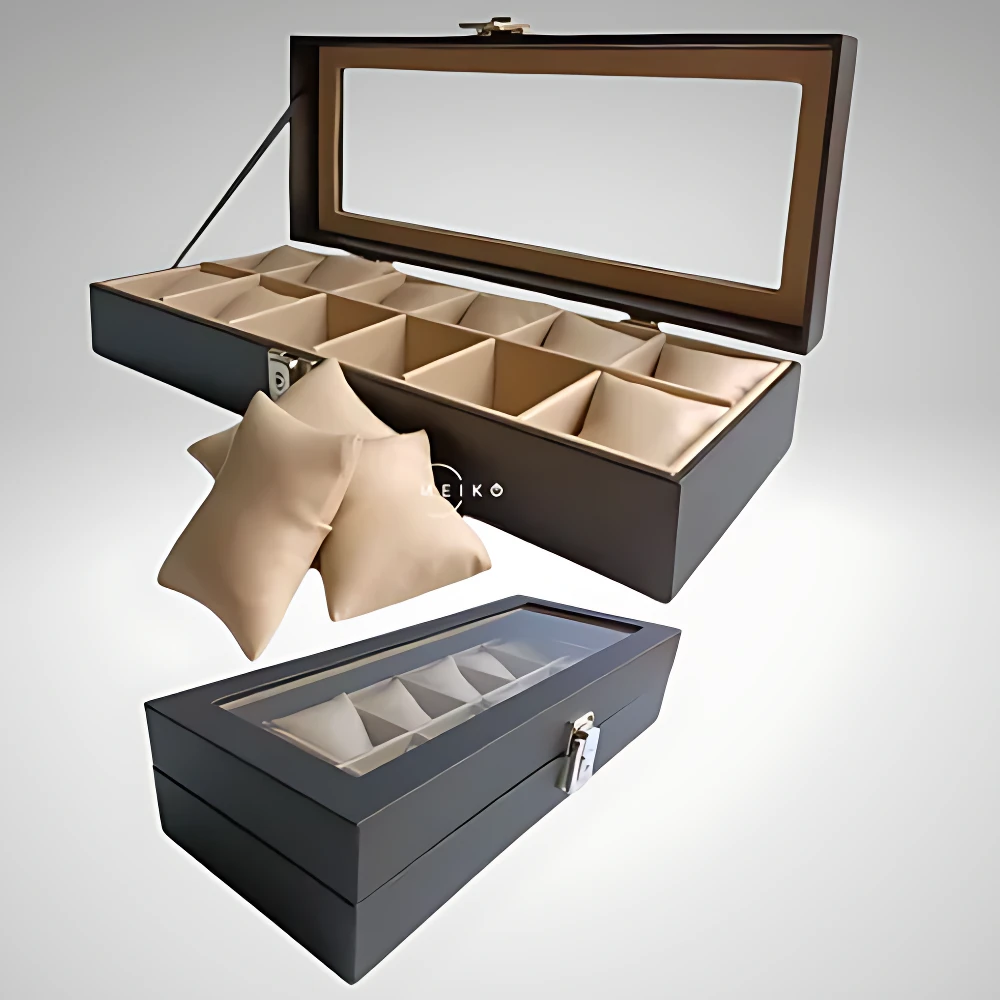 Caja organizadora de relojes de color gris oscuro con cristal superior, mostrando interior con compartimentos individuales y almohadillas protectoras beige. Incluye variante cerrada y abierta, con logotipo visible en lateral.